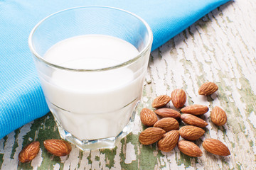 almond milk in a glass, next to lie almonds