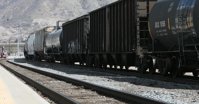 Train railroad cargo tanker cars urban city. Cargo freight trail cars passing in urban city center. Food, liquid or oil fuel container. Heavy industrial commerce transportation.