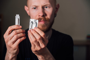 Sad young man holding suppository