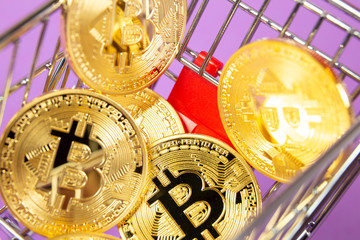Empty shopping cart on the lilas background with bitcoin