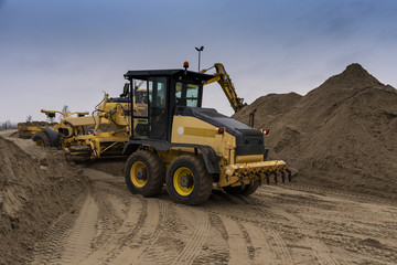 The excavator and bulldozer are preparing sand for loading