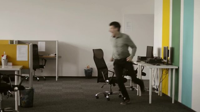 Man just have won a huge prize. He is dancing at the office/ Worker was waiting untill the workday is over and finally it happened, he is happy to have a day off.