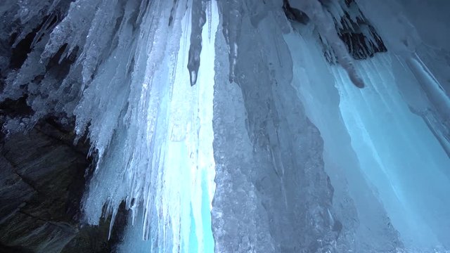 Dolly Close Aaround shiny transparent sharp blue ice hanging lump texture ceiling cave rock inside unique view up. Mystic impress. Winter frost innocent ecology. Russia Baikal Arctic Gimbal