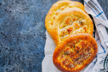 Turkish ramazan pidesi - Traditional Turkish ramadan flatbreads which bake during ramadan month. Blue stone background. Top view.