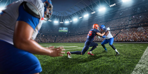 Naklejka premium American football players preforms an action play in professional sport stadium