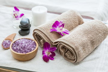Fototapeta na wymiar Beautiful spa composition treatment setting orchid, towels, bath salts ,candle,stone