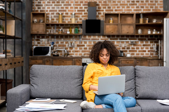 Attractive Young Woman Working Working With Laptop On Couch