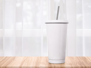 Steel mug on morning backdrops. Insulated drink container.