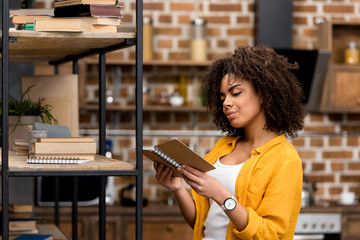 beautiful young woman reading book at home