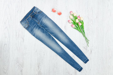 Blue jeans and bouquet of tulips. Fashionable concept