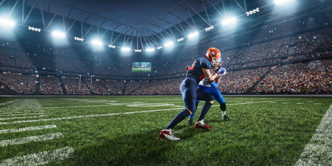 Obraz na płótnie Canvas American football players preforms an action play in professional sport stadium