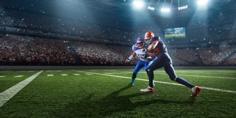 American football players preforms an action play in professional sport stadium