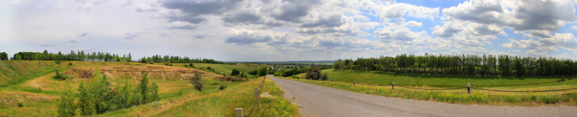 Panorama of the road under the sky with clouds