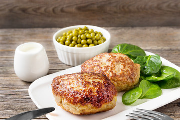 Homemade cutlets with a salad on a plate in a rustic style.