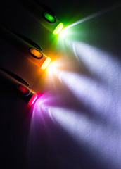 Colorful light beam of flashlight pen on dark background.
