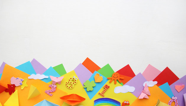 Multicolored Origami and paper on  a white table.