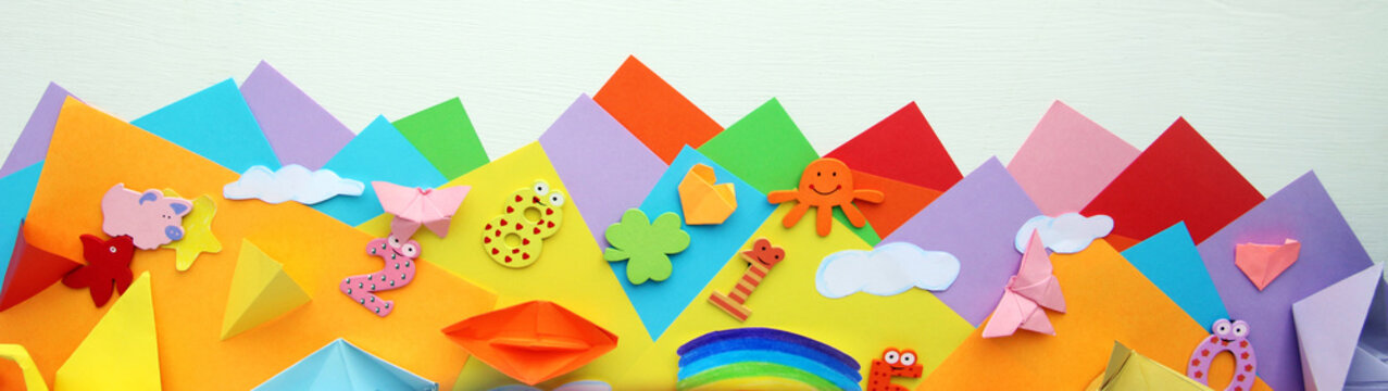  Multicolored Origami and paper on  a white table.