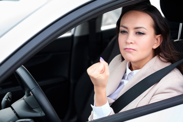 Boorishness on the road. Young woman is showing her fist to someone