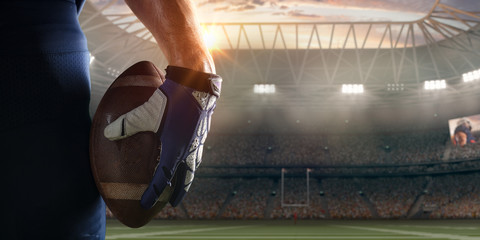 American football players hand with ball in professional sport stadium  © Alex