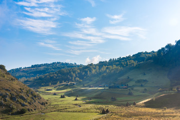Beautiful rural mountain landscape in the morning light with old houses and haystacks, Fundatura Ponorului, Hunedoara County, Romania