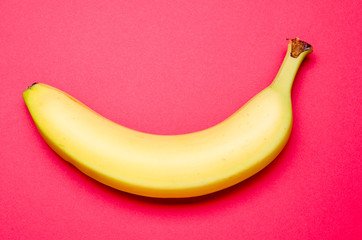 one banana on a red background