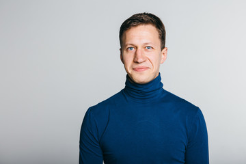 Fototapeta premium Casual guy with a warm smile over white grey background.