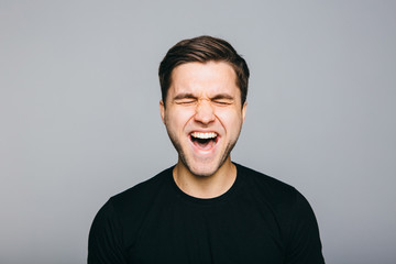 Fototapeta premium Anger, rage, shout man standing on grey background.