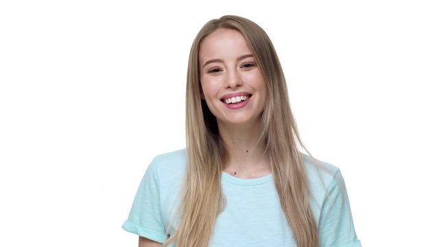 Portrait of hospitable blond woman with long hair smiling on camera and greeting with waving hand, isolated over white background. Concept of emotions