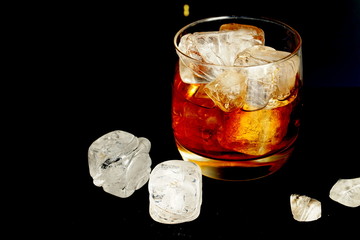 Glass of whisky with ices. Bokeh background.