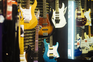 Fototapeta na wymiar Guitars of different colours in music store.