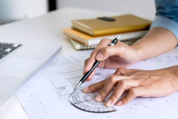 Architect working on blueprint, Engineer working with engineering tools for architectural project on workplace, Construction concept - building project, blueprints, ruler and dividers