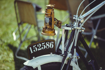 retro motorcycle, brass kerosene headlight of an old motorcycle, springer front fork and an old...