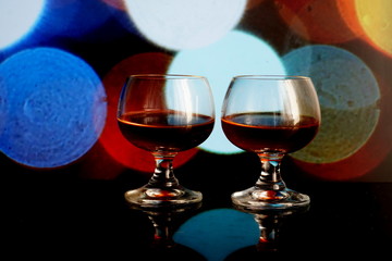Two glass of cognac, bokeh backround.