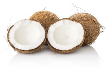 Three coconuts and one cracked in two halves isolated on white background brown fibrous shell with milk meat.