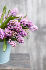 Bouquet of Beautiful violet and lilac hyacinths. Spring flowers in vase on wooden table. bulbous plant. Vertical photo