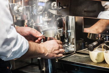 Barista in the cafe or restaurant prepares coffee in the coffee machine