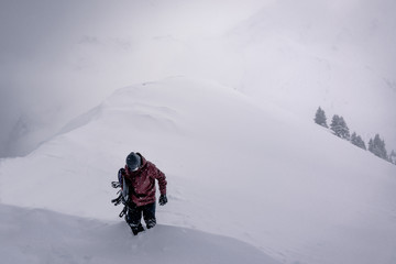 Fototapeta na wymiar Snowboarder besteigt berg