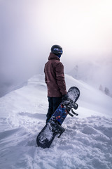 Fototapeta na wymiar Snowboarder steht auf einem Berg