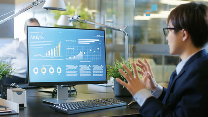 In the Office Businessman Using Personal Computer with Statistical Information and Expressing His Wonder from Successful Growth at His Desk.