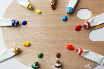 fine art, creativity, painting and artistic tools concept - close up of palette and acrylic color tubes or paint