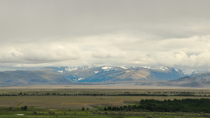 Aerial Altai mountains landscape. Mountain range behind wooded plains