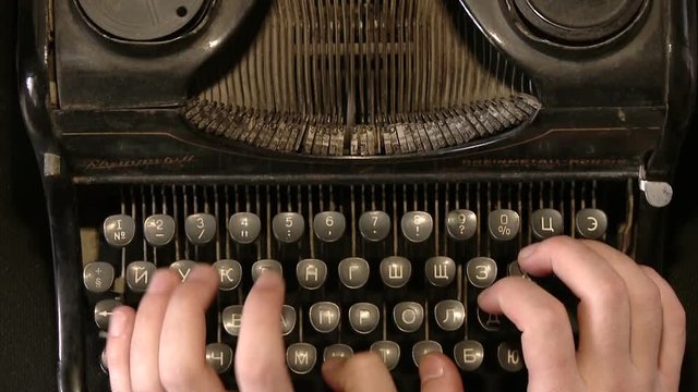 Writer typing with retro writing machine. View from above.