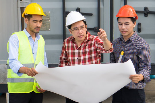 Concept Teamwork of building construction staff. Project engineer / contractor reviewing plan of work with foreman and worker at construction site.