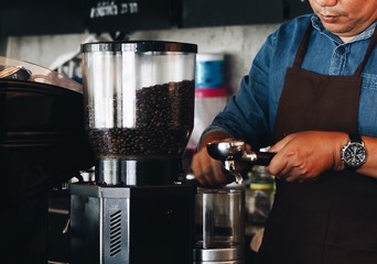 Asian man making a coffee in cafe.