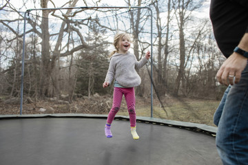 Young girl jumping on trampoline