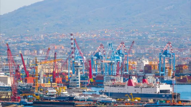 Time lapse of the sea port with a lot of cranes and cargo containers. Zoom out effect