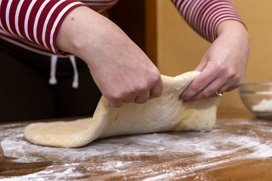 Women's hands prepare a donut dough