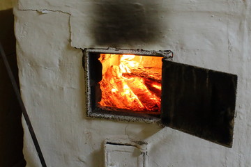 A home-made brick oven painted white, for heating the house and cooking food. Russia. Russian stove.