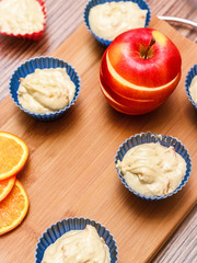 Dough in colored silicone forms on a wooden background. View from above. Cooking Houses. Home kitchen