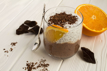 Chocolate pudding with chia and orange on the white wooden background